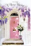 This photograph portrays an inviting Old Ford front step that feels like a love letter to new beginnings. A pastel pink door, painted in a soft, welcoming shade, forms the focal point, sitting snugly within crisp whitewashed walls that glow in diffused daylight. Overarching the entrance, generous clusters of lavender wisteria trail in elegant strands, each blossom-laden stem creating a veil of purple that filters the light and scatters intricate shadows across the door and stone step, reminiscent of the flowering vines that soften many corners around Bow and the nearby canal paths. At the threshold, a vintage-style metal bucket has been placed with care, overflowing with an abundant bouquet of creamy white roses. The rose heads are full and plush, their petals layered in velvety spirals that invite the imagination to feel their softness. Between them, fresh green foliage adds movement and a slightly untamed charm, suggesting blooms that are fresh, local, and thoughtfully arranged. A gentle pink ribbon encircles the bucket, tied into a simple bow whose soft sheen echoes the tone of the front door and subtly ties the composition together. There is a stillness to the scene, yet also a sense of anticipation-as if someone has just moved into their new place near Roman Road or along Old Ford Lock, and this arrangement is their first floral welcome. The mood is tender, hopeful, and deeply homely, making it a perfect visual metaphor for a housewarming gift or congratulatory flowers delivered to mark the start of a new chapter in E3, where each petal and leaf speaks quietly of warmth and belonging.