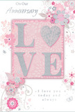 The card in the image offers a gentle, intimate vision of enduring romance, rendered in a soft blend of pastel pinks, whites, and shimmering greys. At its centre, the word LOVE appears in raised, glittering letters, the glitter applied with care so that the surfaces glow rather than sparkle harshly. The O is transformed into a silver-toned heart, textured and luminous, becoming a focal point that suggests two hearts held together through time. This central word is set against a blush-pink panel that subtly stands out from the rest of the design, giving the impression of layers, much like petals within a rose. Surrounding it, delicate floral illustrations unfold with the airy grace of watercolour, petals painted in blush and mauve, softened with misty grey shadows. Fine lines curl around the blossoms like tendrils, recalling the flowing greenery of a bouquet arranged by a florist familiar with Old Ford, perhaps on the way to a celebration near Victoria Park or along the Regent's Canal. Tiny details - discreet butterflies, small swirls, and petal-like accents - are scattered across the background, adding playfulness and motion without disturbing the card's calm mood. The phrases On Our Anniversary and a tender promise of constant love are written in a refined, understated script, their curves echoing the shapes of the vines and stems. The overall effect is that of a treasured memento: soft, whisper-like, yet full of meaning. It feels like the perfect companion to an anniversary bouquet, ready to rest on a mantelpiece or side table in an Old Ford home, quietly celebrating a shared journey and the comforting beauty of lasting affection.